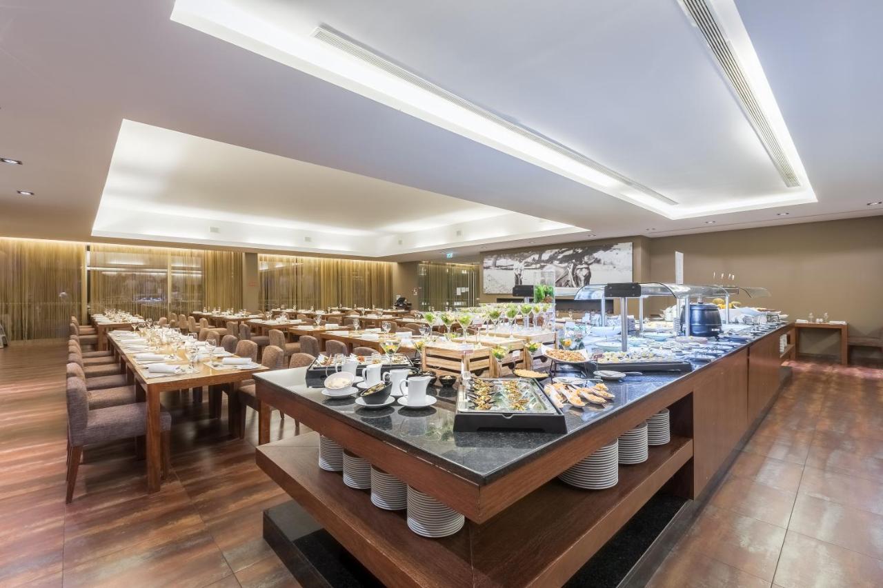 拉戈芒塔格别墅瑙酒店 蒙塔吉尔 外观 照片 The photo displays a spacious restaurant interior, featuring a well-organized dining area with multiple tables set for patrons. In the center, there is a large buffet station filled with an array of food items. The decor is modern and elegant, with w
