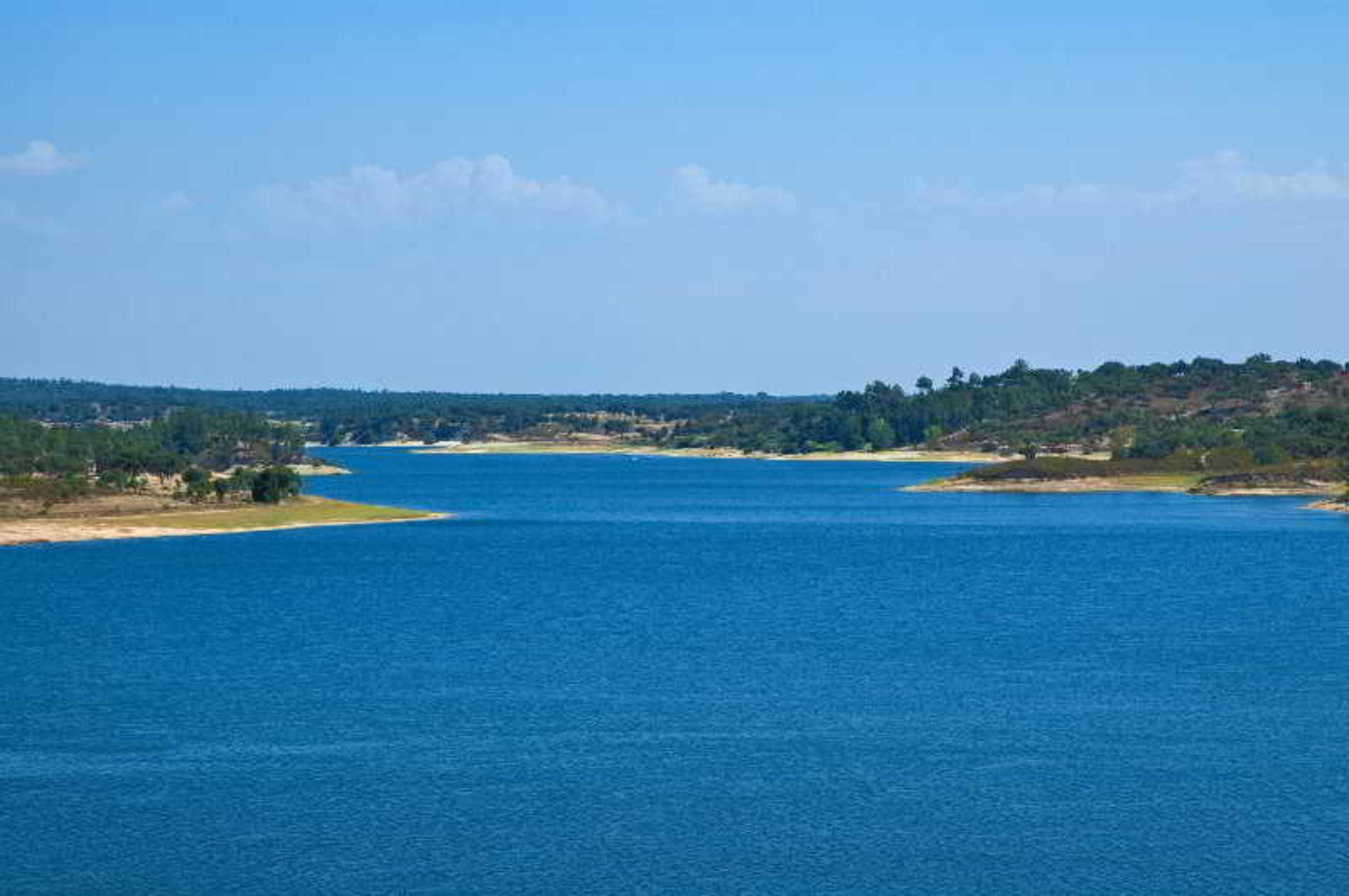 拉戈芒塔格别墅瑙酒店 蒙塔吉尔 外观 照片 The photo depicts a serene landscape featuring a large body of water, likely a lake or river. The water appears calm and is reflecting a clear blue sky with some clouds. Surrounding the water, there are patches of green land and trees, indicating a n